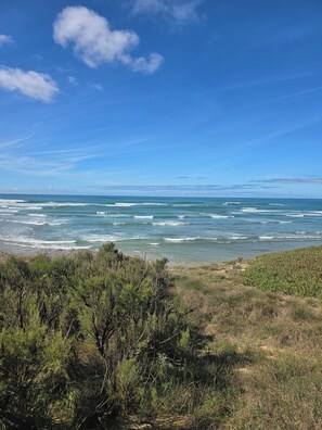 A coastal landscape with ocean waves, clear sky, and dense vegetation. - PLAGE ET GARE A PIED-MAISON TYPE LOFT- (Les Sables-d'Olonne)