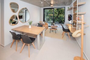 A modern interior with a dining area, a sofa, and a balcony with a view. - First del Sol 1BR | Balcony, Pool, Gym & Parking (Asunción)