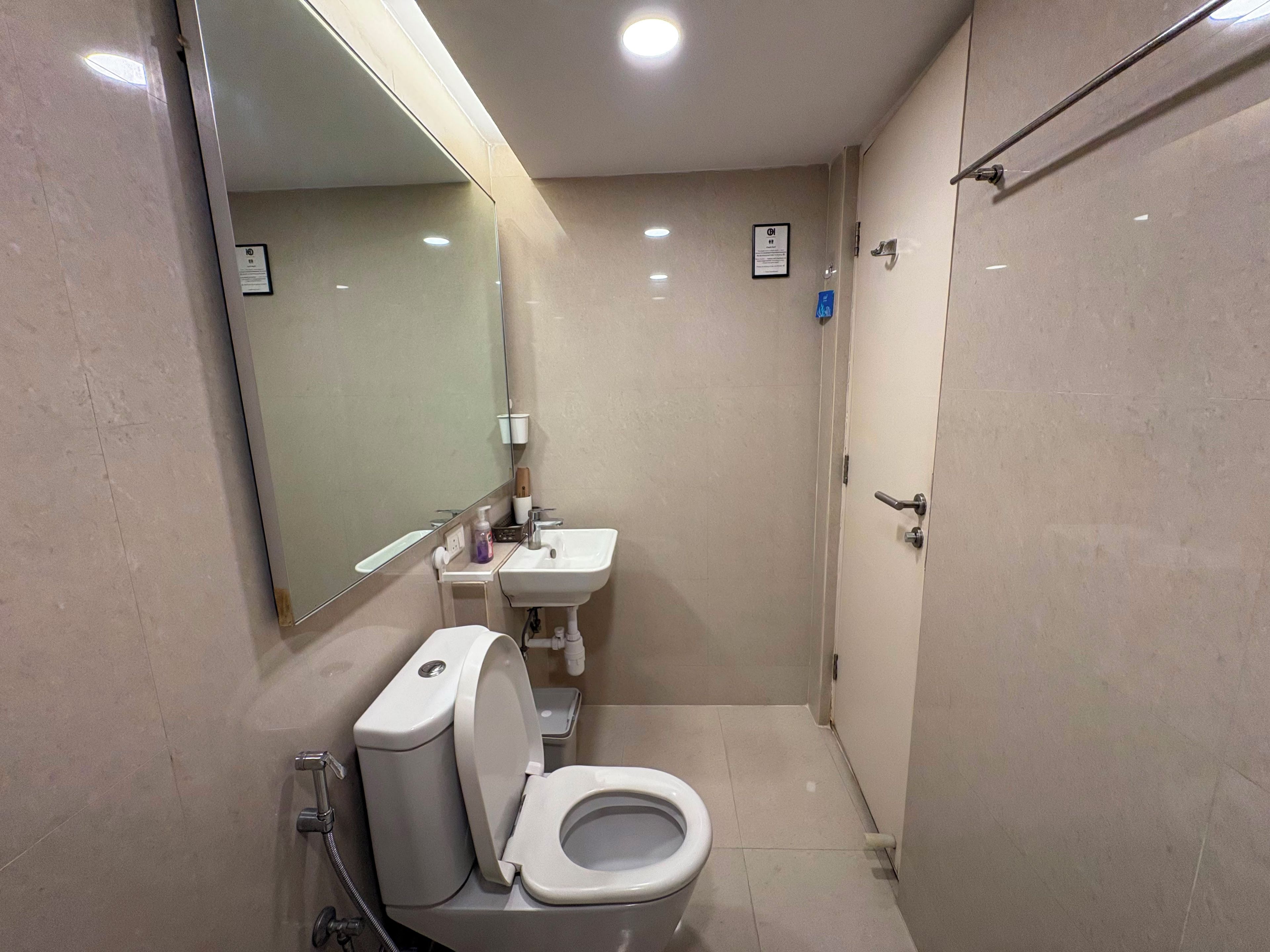Un baño pequeño con inodoro, lavamanos y espejo.