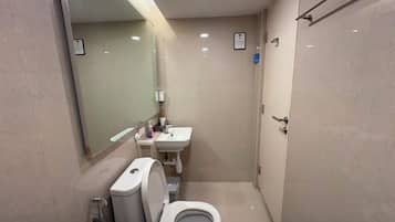 Un baño pequeño con inodoro, lavamanos y espejo.