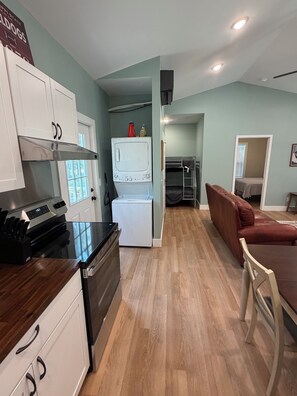 Un espacio habitable compacto con kitchenette, comedor y una pequeña zona de estar.