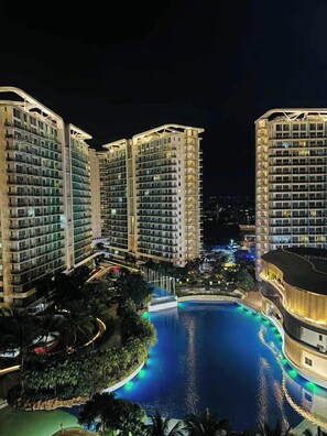A multi-story hotel with a swimming pool surrounded by greenery. - Studio Premium Suite (Paranaque)