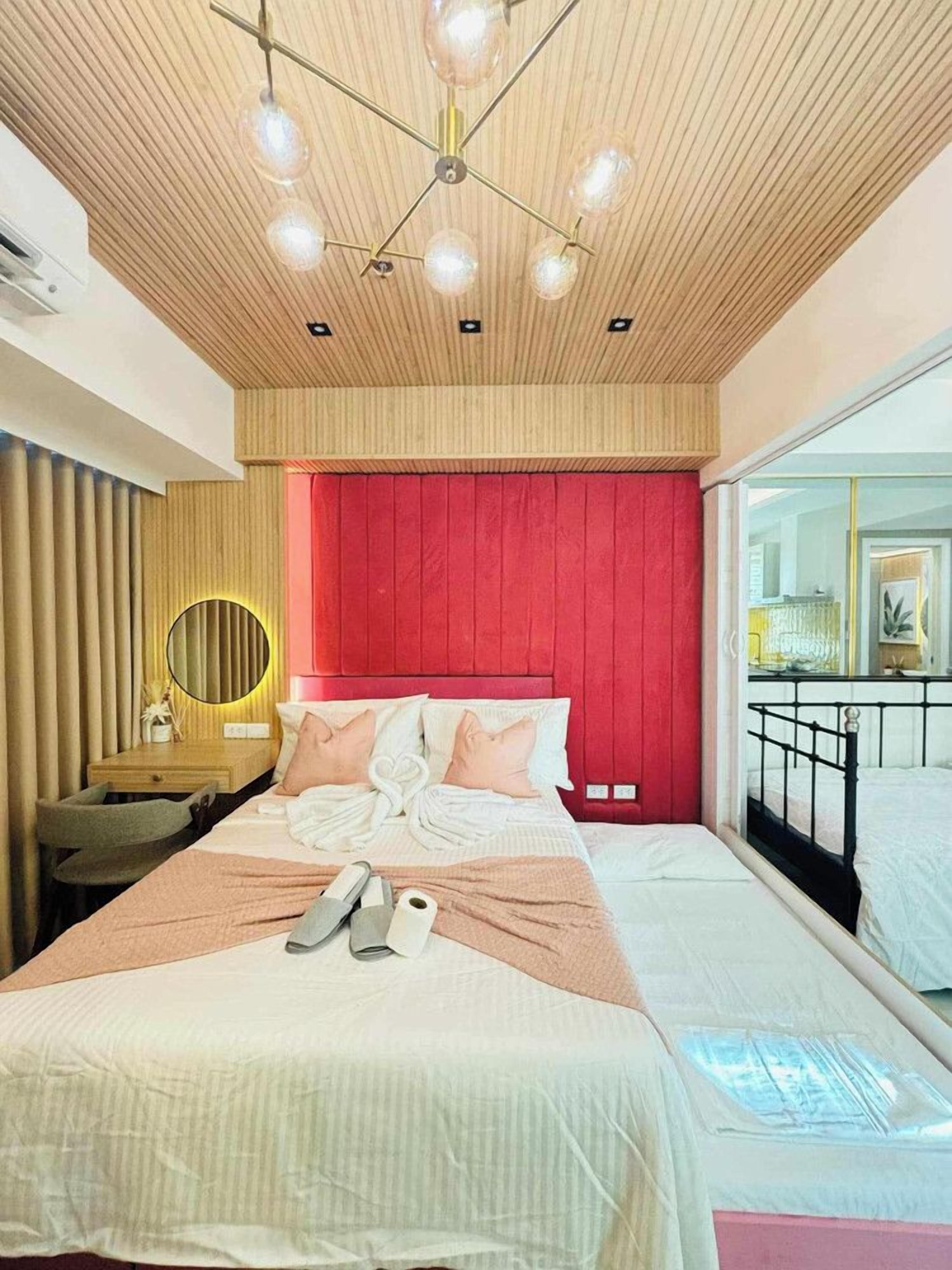 A bedroom with a bed, bedside table, and a mirror.