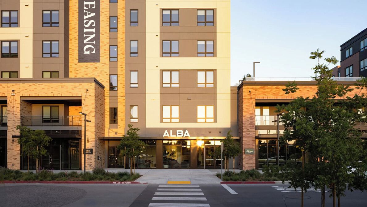 A multi-story building with a prominent 'ALBA' sign at the entrance.