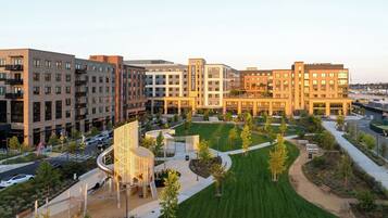 A modern hotel complex with multiple buildings, a central courtyard with greenery, and a parking area.