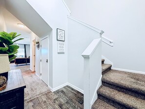 A staircase with a white handrail and carpeted steps leading to a landing. - Jax Beach Haven 4 bd/Movie Room/Dinning/ Downtown (Jacksonville)