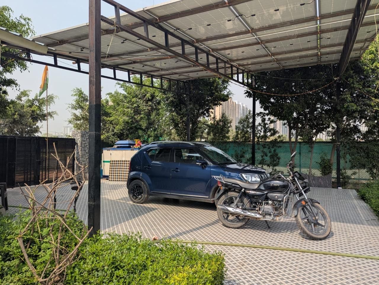 A covered parking area with a motorcycle and a car.