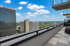 A hotel balcony with a view of surrounding buildings and a clear sky. - Legacy Gold Penthouse | 2 King BD/ 2 BA| Pool | Balcony | Walk Everywhere (Atlanta)