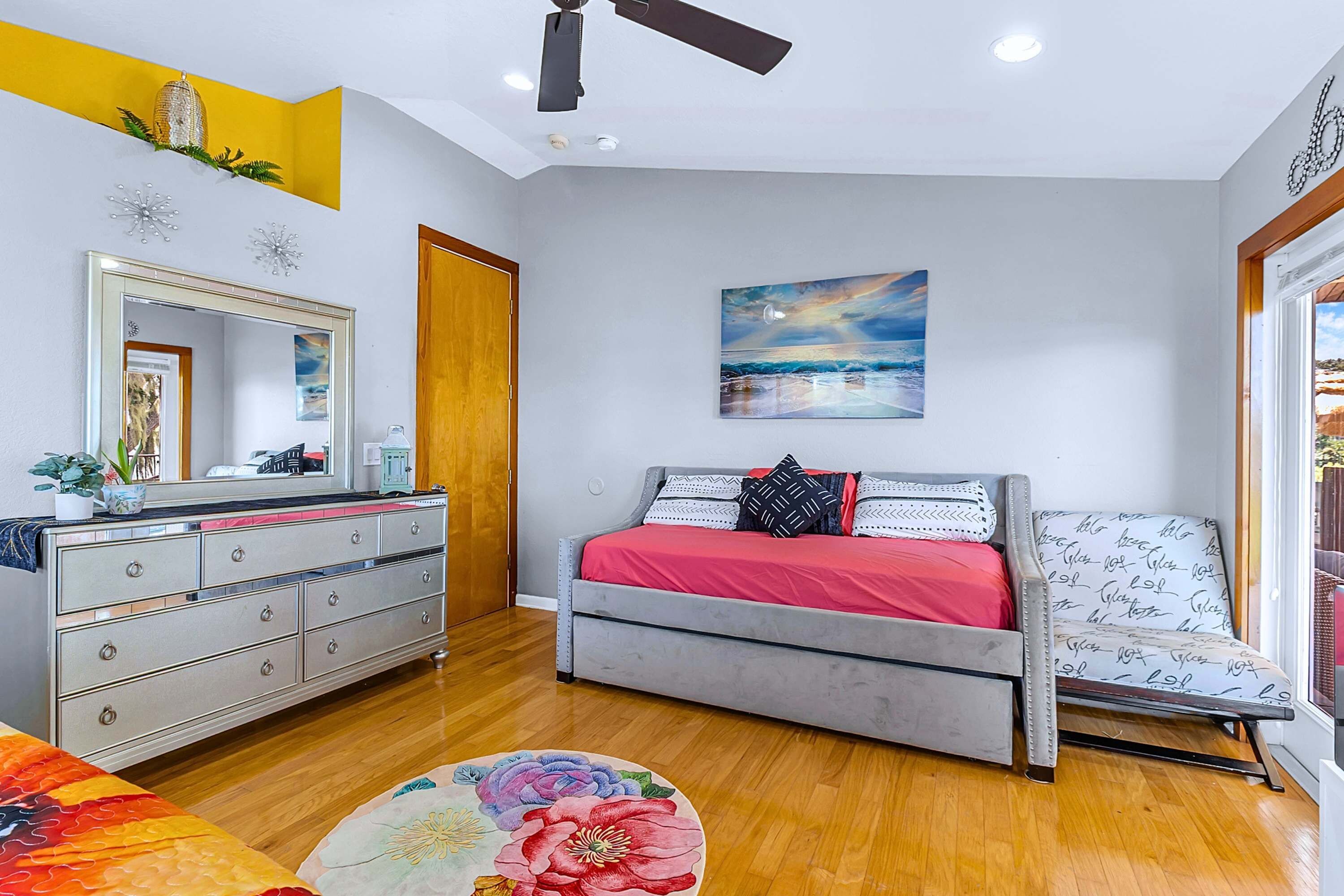 Un dormitorio con cama, cómoda, espejo y obras de arte.