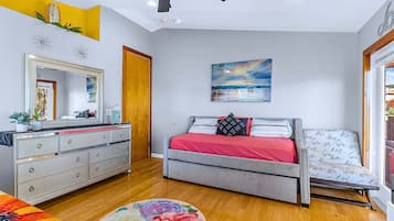 Un dormitorio con cama, cómoda, espejo y obras de arte.