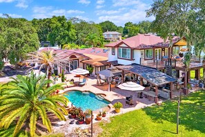 Imóvel residencial com piscina, área de estar externa e varanda coberta.