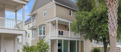 A two-story house with a covered porch and a garage.
