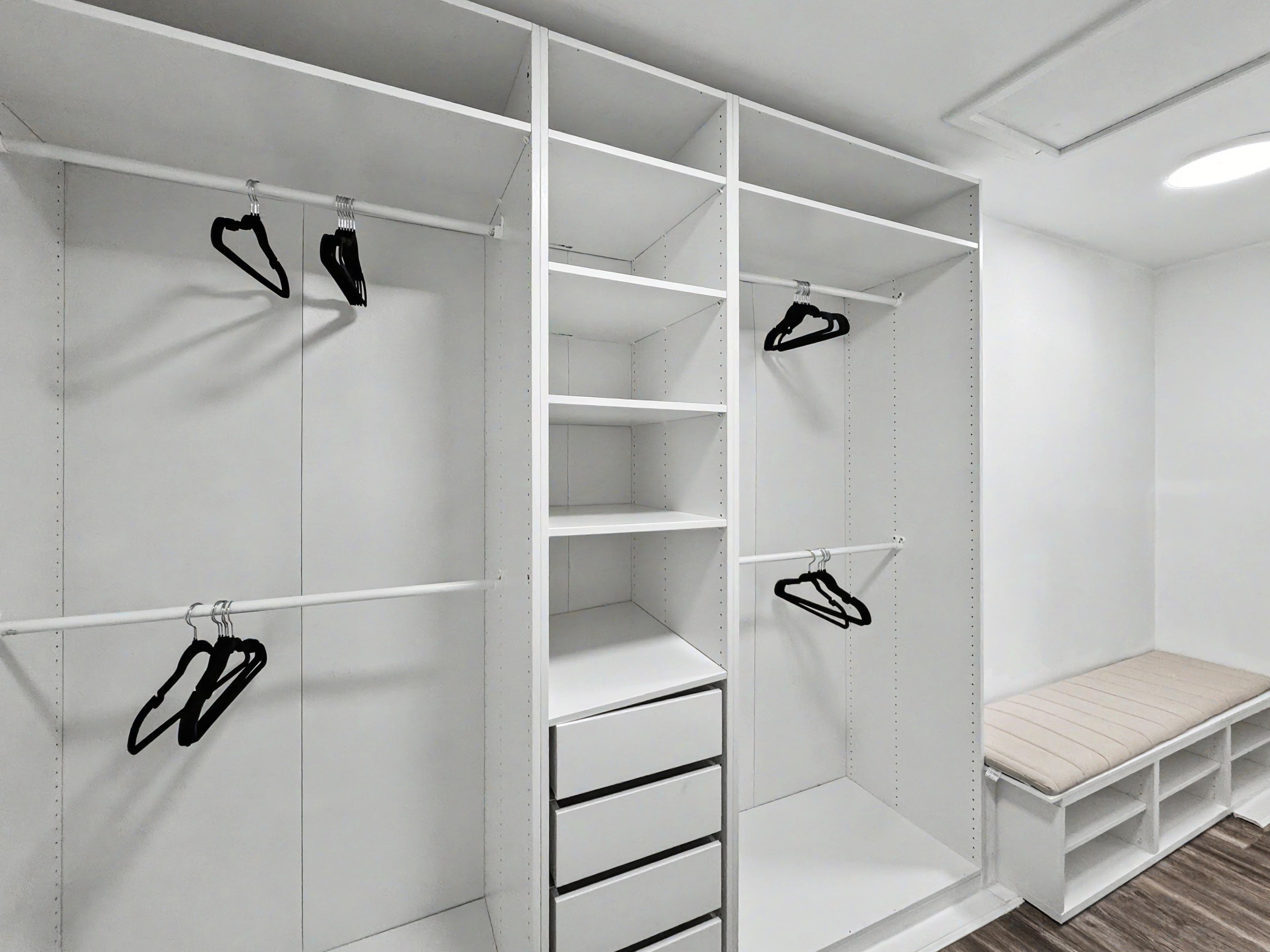 Un dressing avec de nombreuses étagères et un espace pour suspendre les vêtements, un banc et un porte-chaussures.
