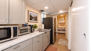 A compact kitchen with a microwave, toaster, refrigerator, and a small sink. - Cheyenne Plains 2 bedroom (Cheyenne)