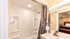 A bathroom with a bathtub, a shower, a vanity with a mirror, and a toilet. - Cheyenne Plains 2 bedroom (Cheyenne)