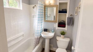 Un baño con bañera, lavamanos, inodoro y ventana.
