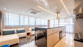 Cozinha moderna com ilha central, eletrodomésticos embutidos e bancada elegante.