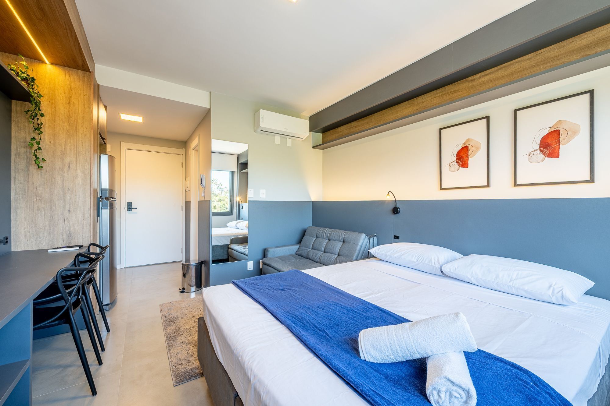 Ein modernes Hotelzimmer mit einem Bett, einem Schreibtisch und Stühlen.