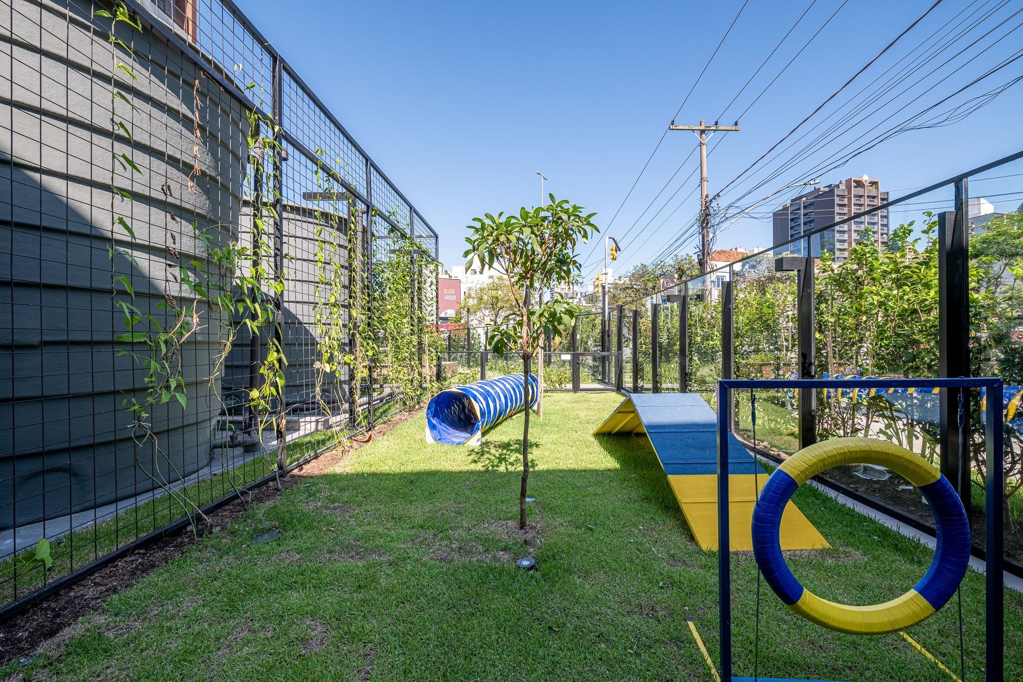 Un área de juegos al aire libre, cercada, con un tobogán y estructuras para escalar.