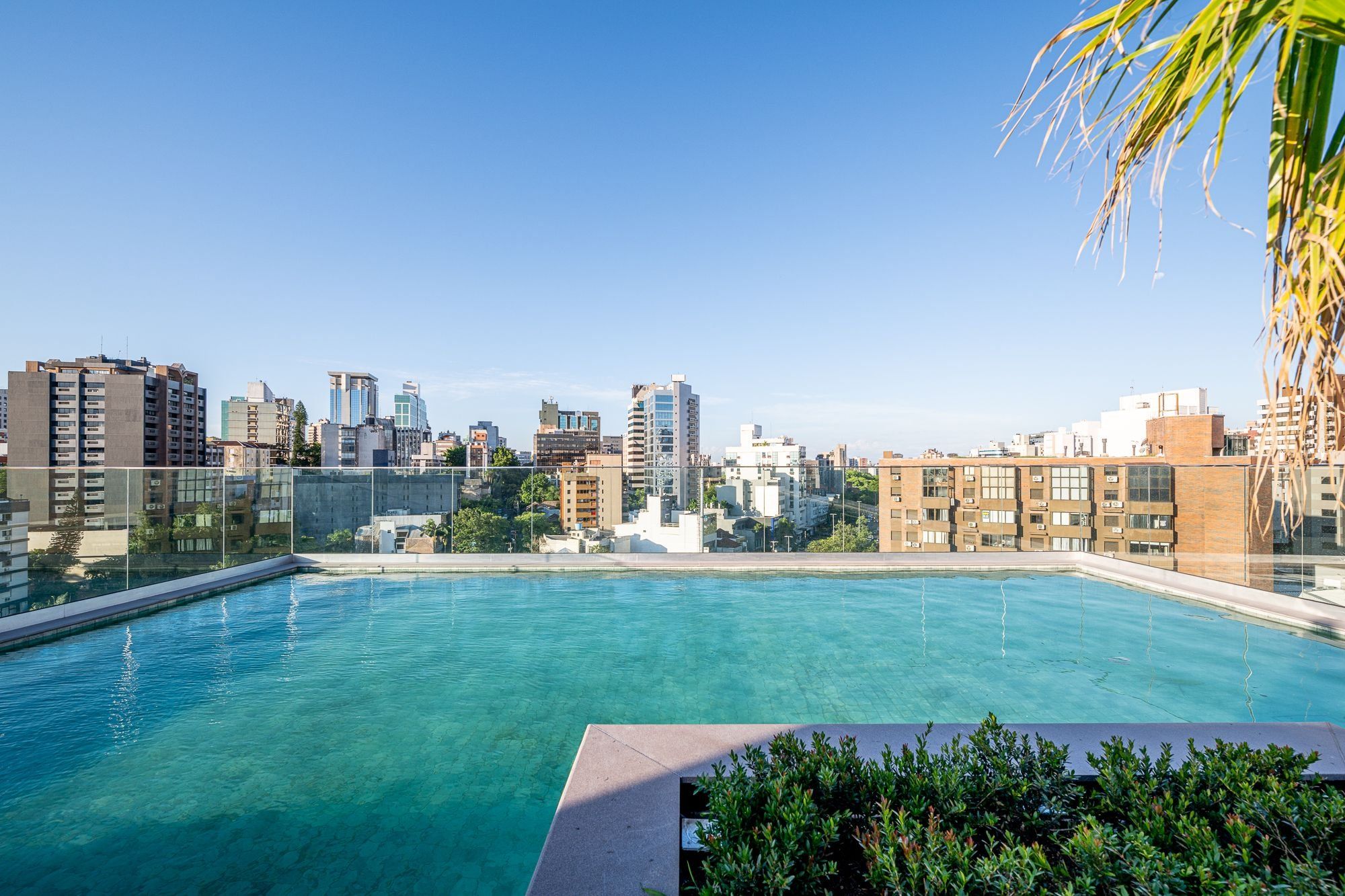 Una piscina en la azotea con vistas a un paisaje urbano, rodeada de edificios.