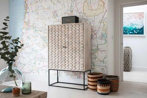 A room with a map on the wall, a cabinet with a nameplate, and decorative baskets. - 6 Bed in Mawgan Porth (oc-b584421) (Mawgan Porth)