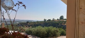 A view from a balcony overlooking a hilly landscape with trees and distant mountains. - A renovated stone house with a view, ideal for quiet family moments (Galia)
