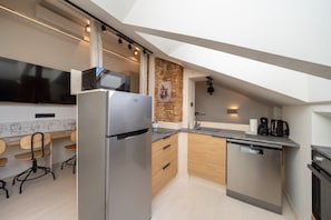 A modern kitchen with a built-in microwave, a refrigerator, a dishwasher, and a coffee maker. - Brand-New Scandi Attic Loft | 5 Separate Beds (Riga)