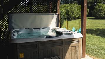 A hot tub with a wooden exterior, a metal lid, and a control panel.