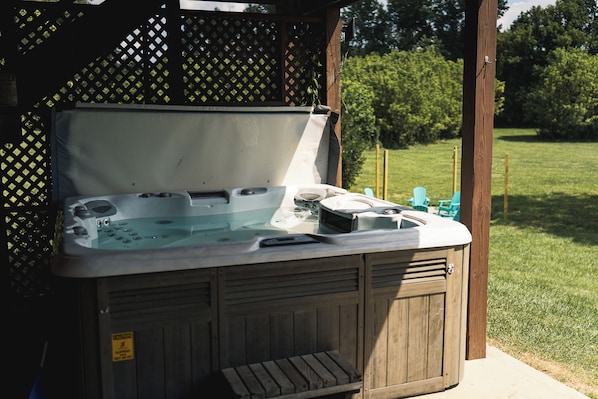 A hot tub with a wooden exterior, a metal lid, and a control panel.