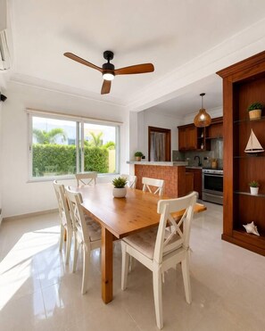 Eine moderne Küche mit Essbereich, Holzausstattung und Deckenventilator.