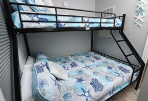A bunk bed with a blue and white patterned bedding, a ladder, and a wall with star decorations. - Shores Of Panama #1215 Paradise awaits! Stunning Beach views! (Panama City Beach)