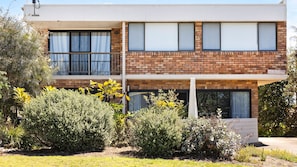 A two-story building with a brick facade, large windows, and a balcony. - Plovers Nest (Peregian Beach)