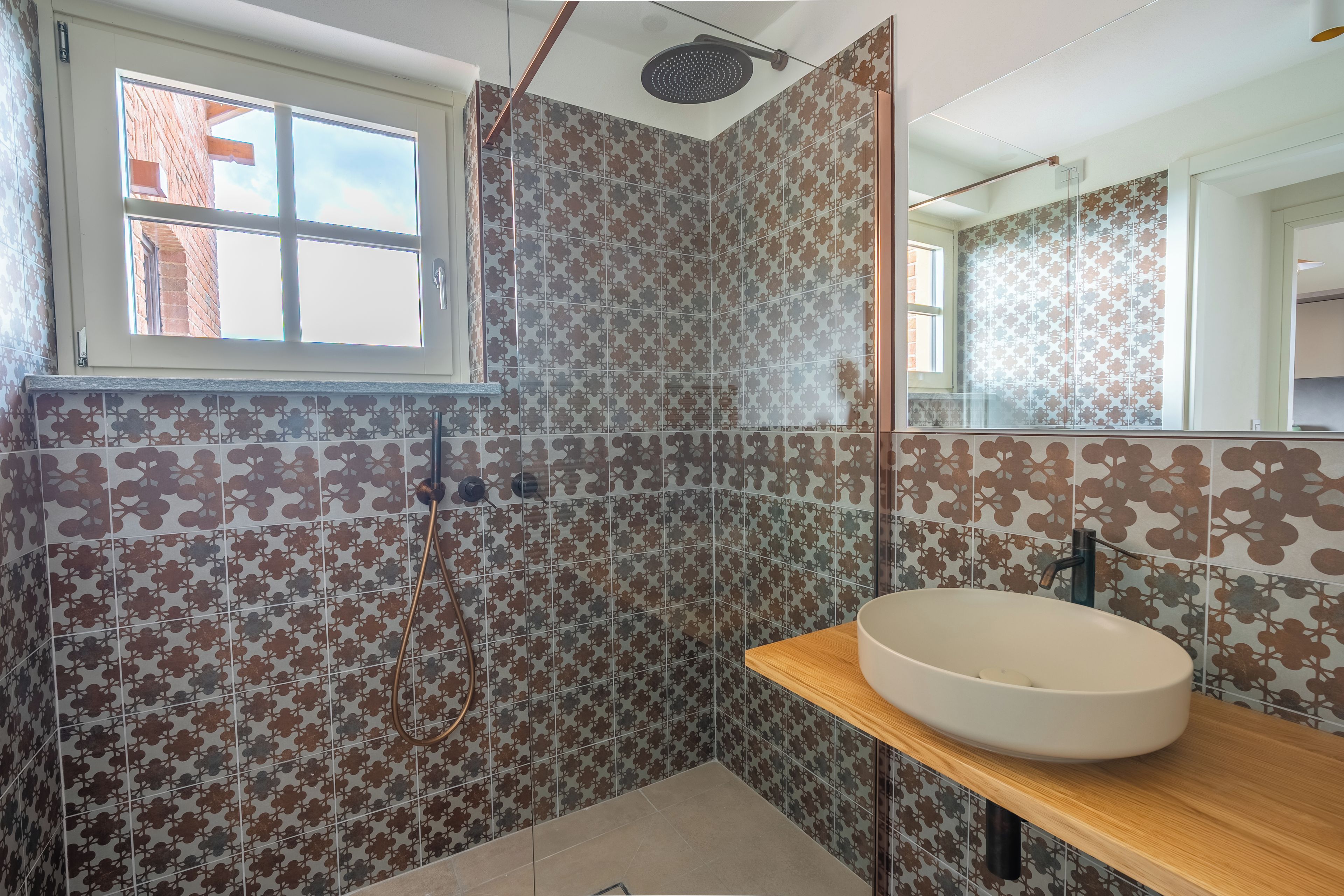 Ein Badezimmer mit Dusche, Waschbecken und Fenster.