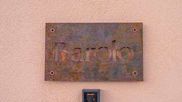 Un cartello di metallo arrugginito con la scritta 'Barolo' fissato a una parete.