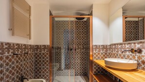 Een badkamer met een bad, een douchecabine en een wastafelmeubel.