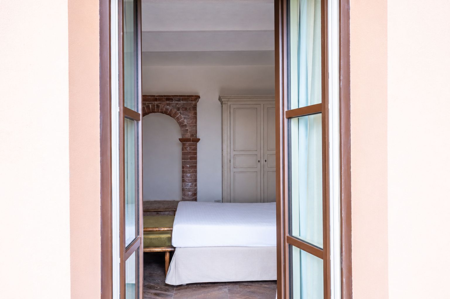 Ein Zimmer mit einem Bett, einem Kamin aus Ziegelsteinen und einem Kleiderschrank.