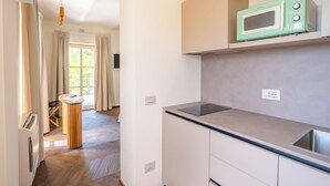 Eine moderne Küche mit Einbau-Mikrowelle, Spüle und einem Holzes Esstisch.