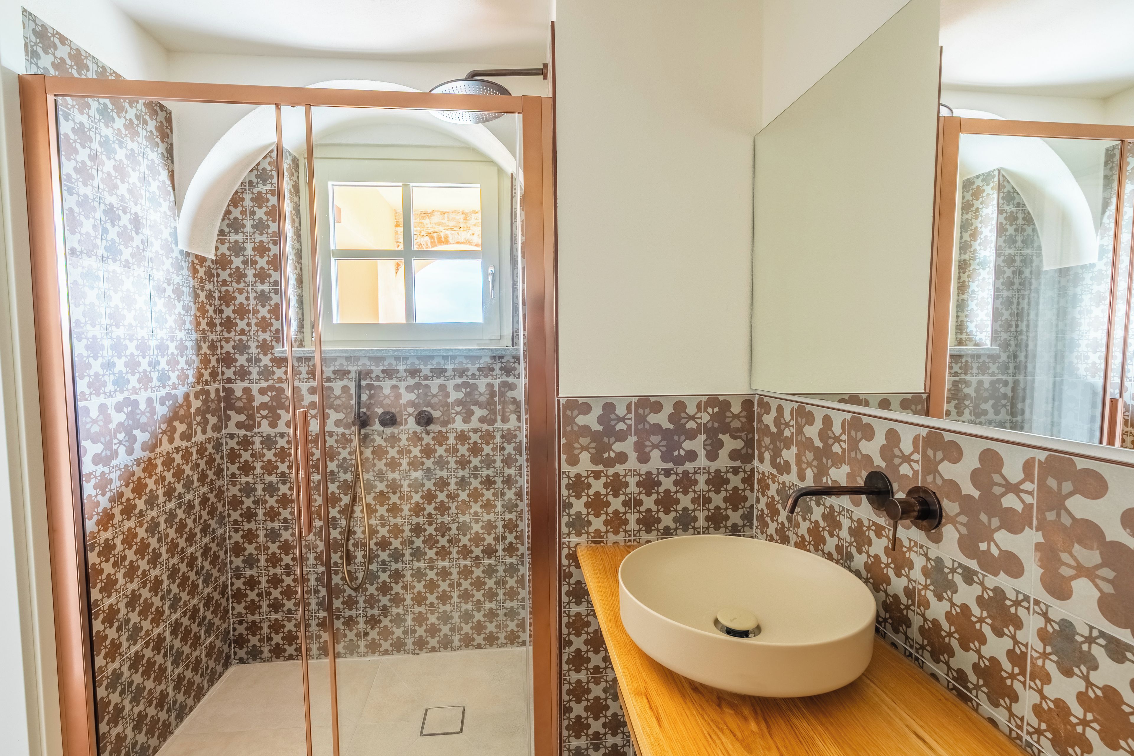 Une salle de bain avec une douche, un lavabo et un miroir.