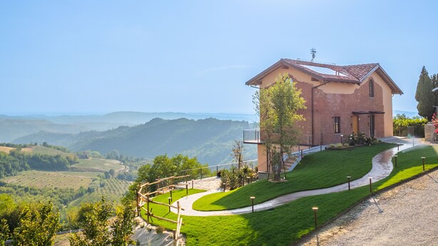 Ein Haus mit befestigter Auffahrt und Blick auf sanfte Hügel.