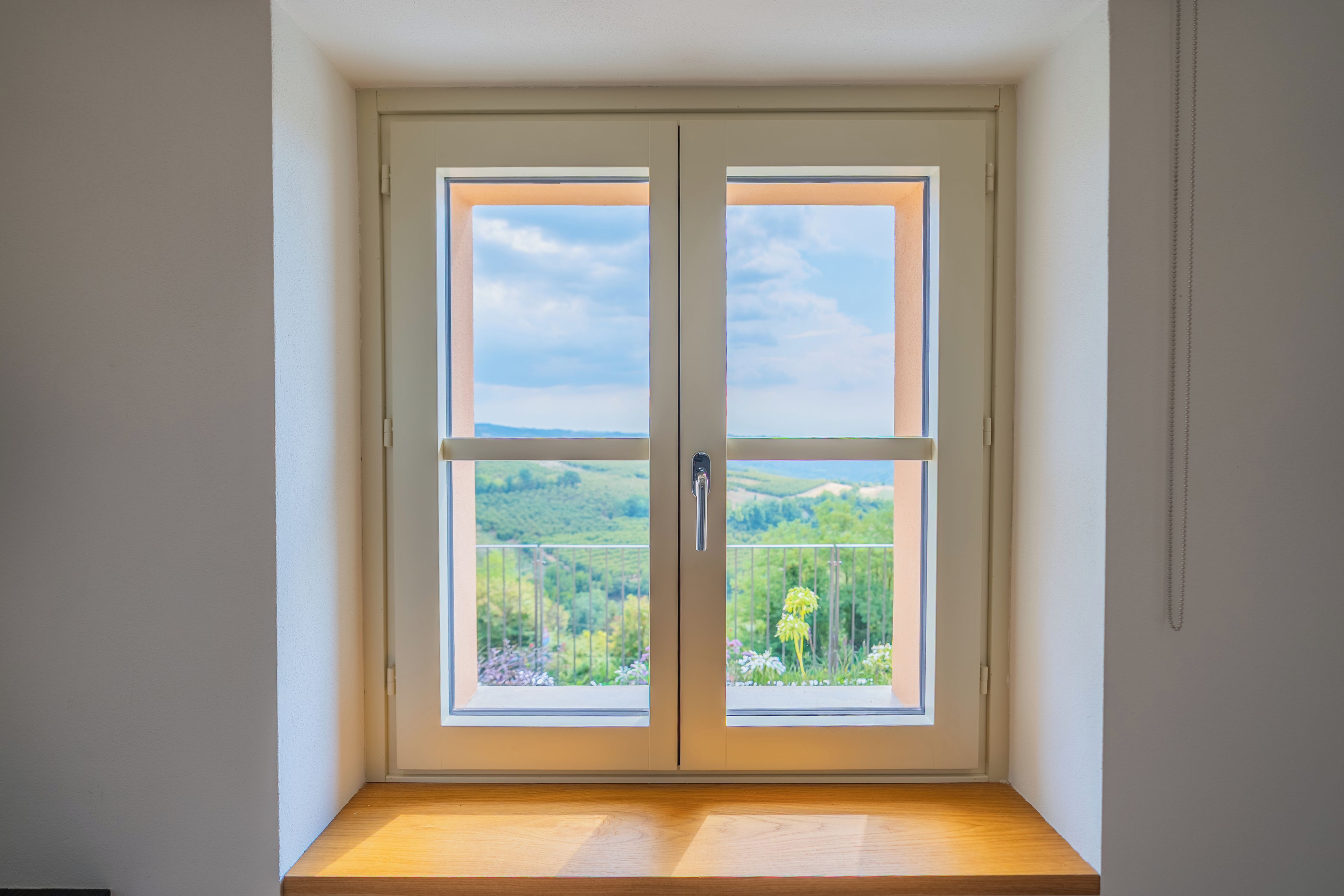 Une pièce dotée d’une fenêtre à double porte donnant sur un paysage.