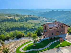 Uma casa com telhado inclinado, painéis solares e vista para um vale.