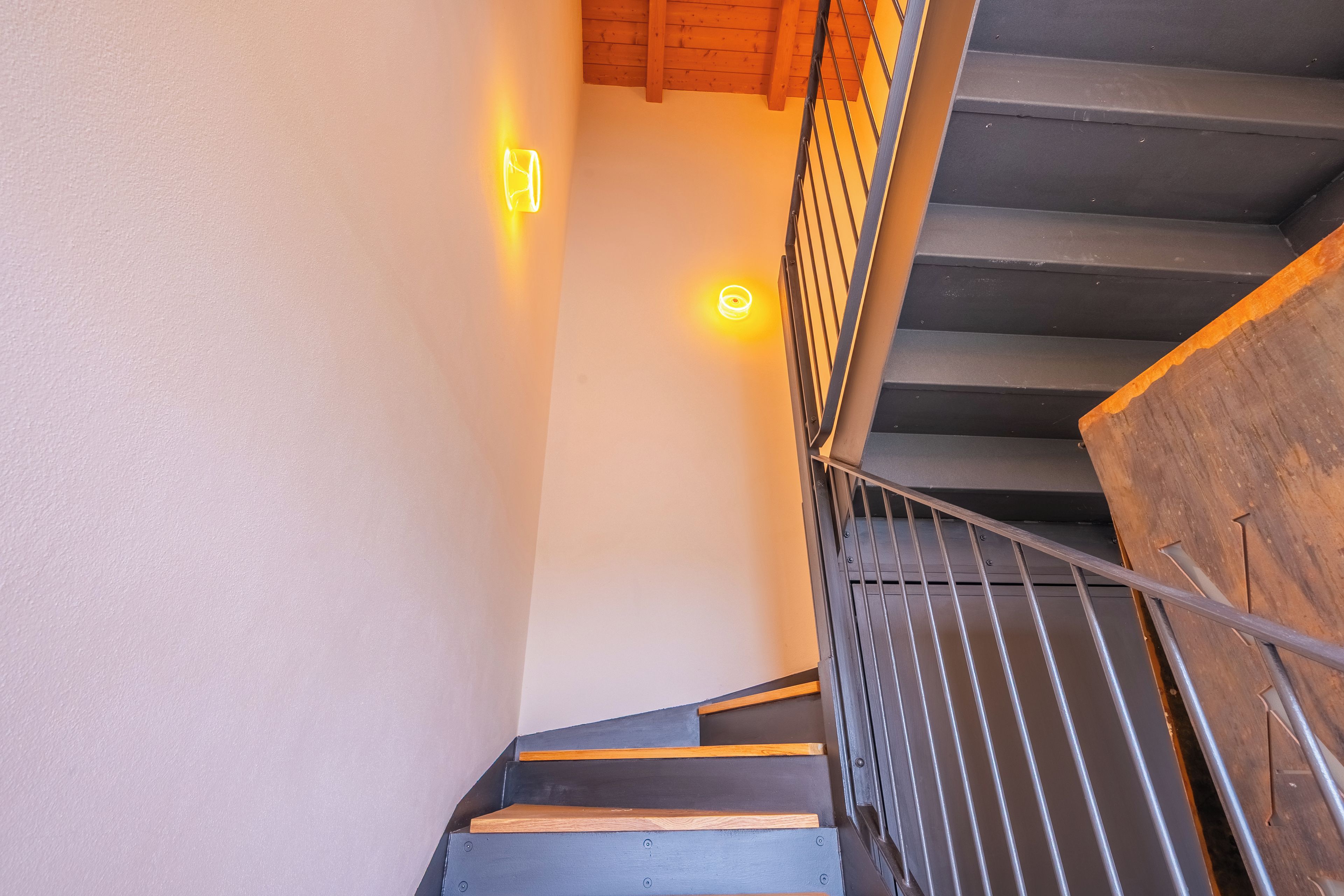 A staircase with a metal railing and wooden steps.