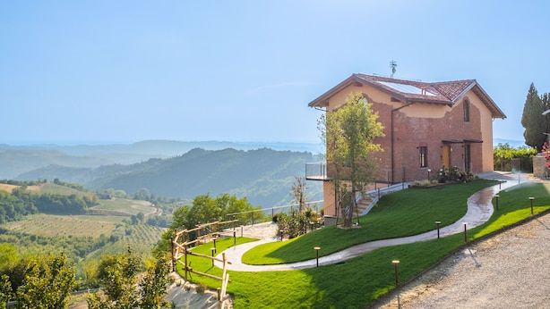 Ein Haus mit befestigter Auffahrt und Blick auf sanfte Hügel.