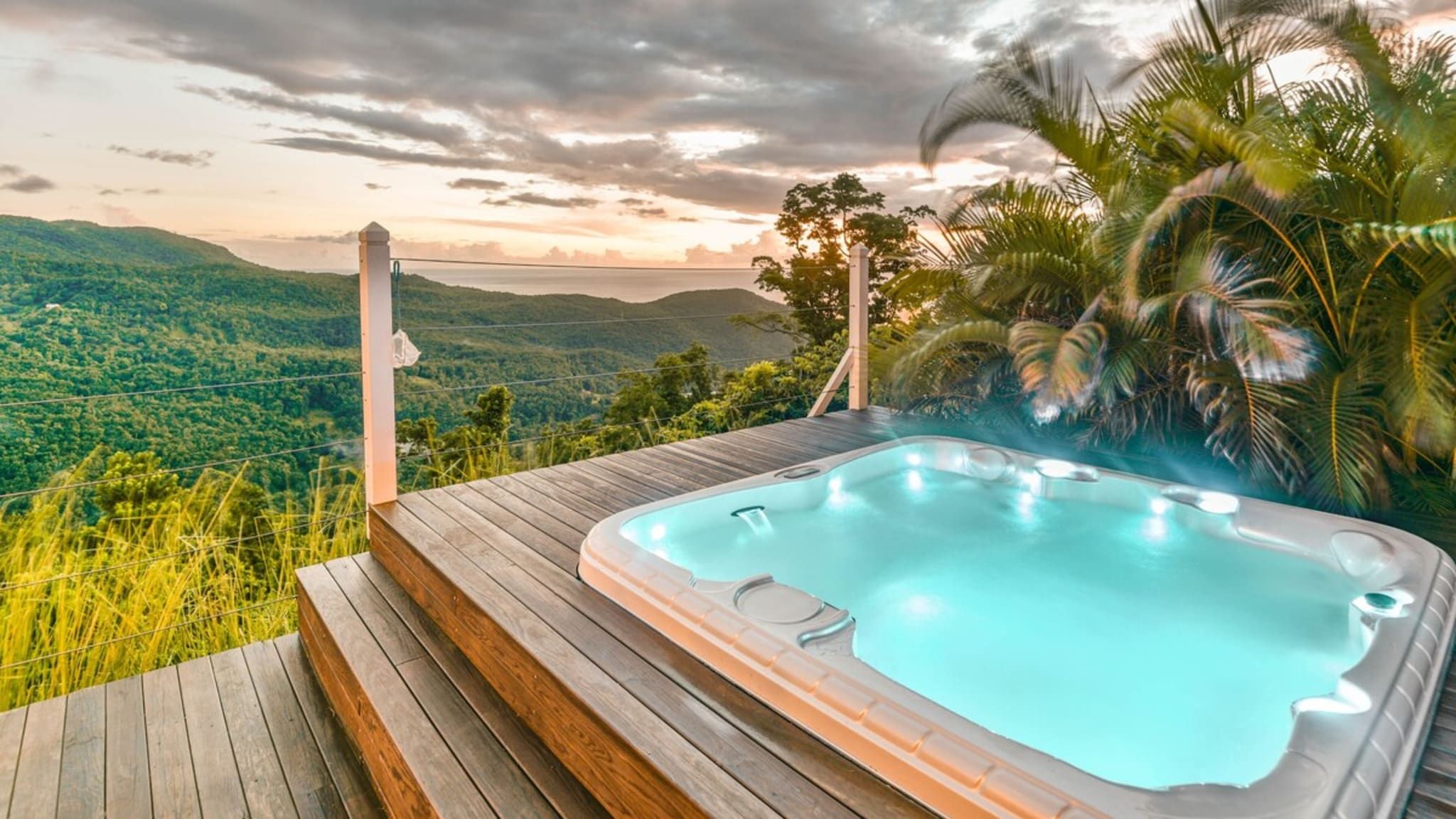 Ein Whirlpool auf einer Holzterrasse mit Blick auf eine Berglandschaft.