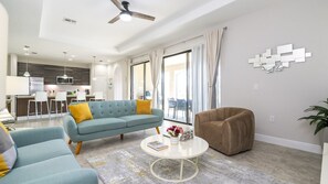 A modern living room with a sofa, armchair, and coffee table. - Balmoral 4BR Villa Pool & Lake View Near Legoland (Haines City)