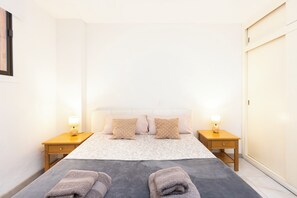 A hotel room with a bed, two bedside tables, and a wardrobe. - Home2Book Sea View Terrace Puerto Santiago (Puerto Santiago)