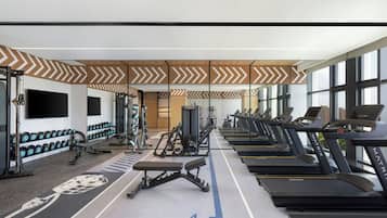A gym with treadmills, dumbbells, and weight machines.