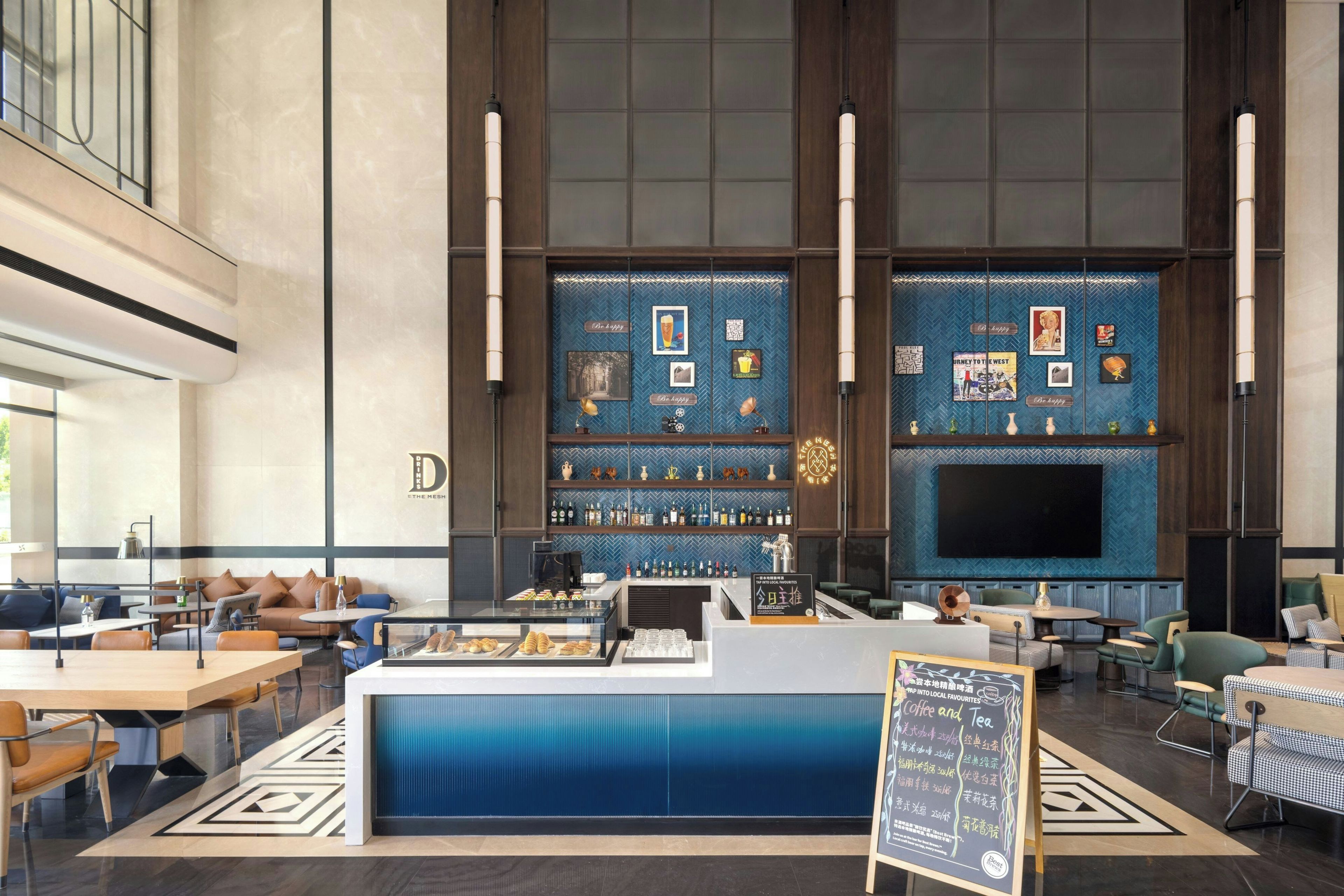 A modern bar area with a counter, seating, and a large screen.