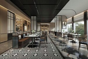 Un restaurante moderno con una barra larga, zona de asientos y grandes ventanales.