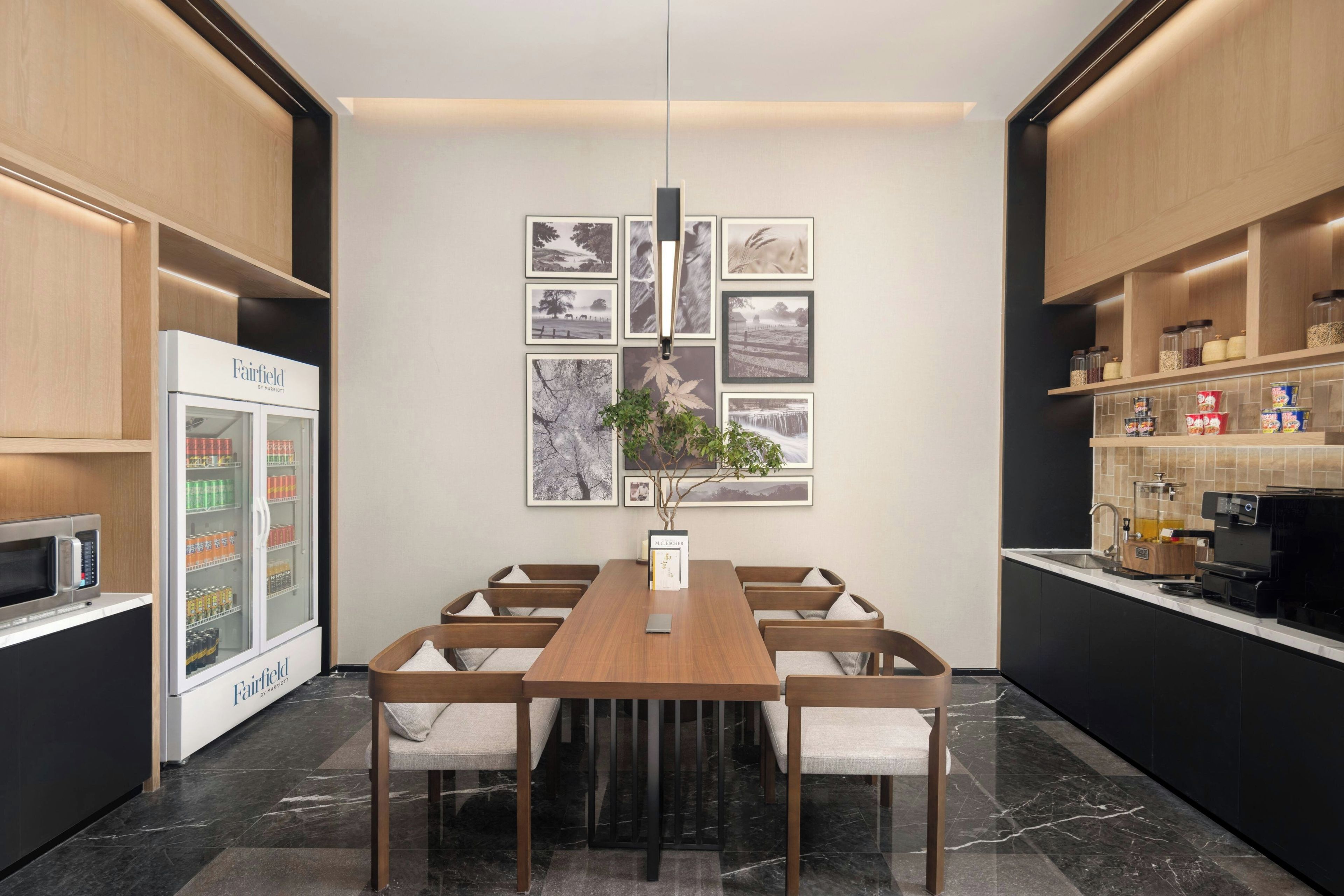 Una cocina moderna con una mesa de madera, sillas, un refrigerador y una cafetera.